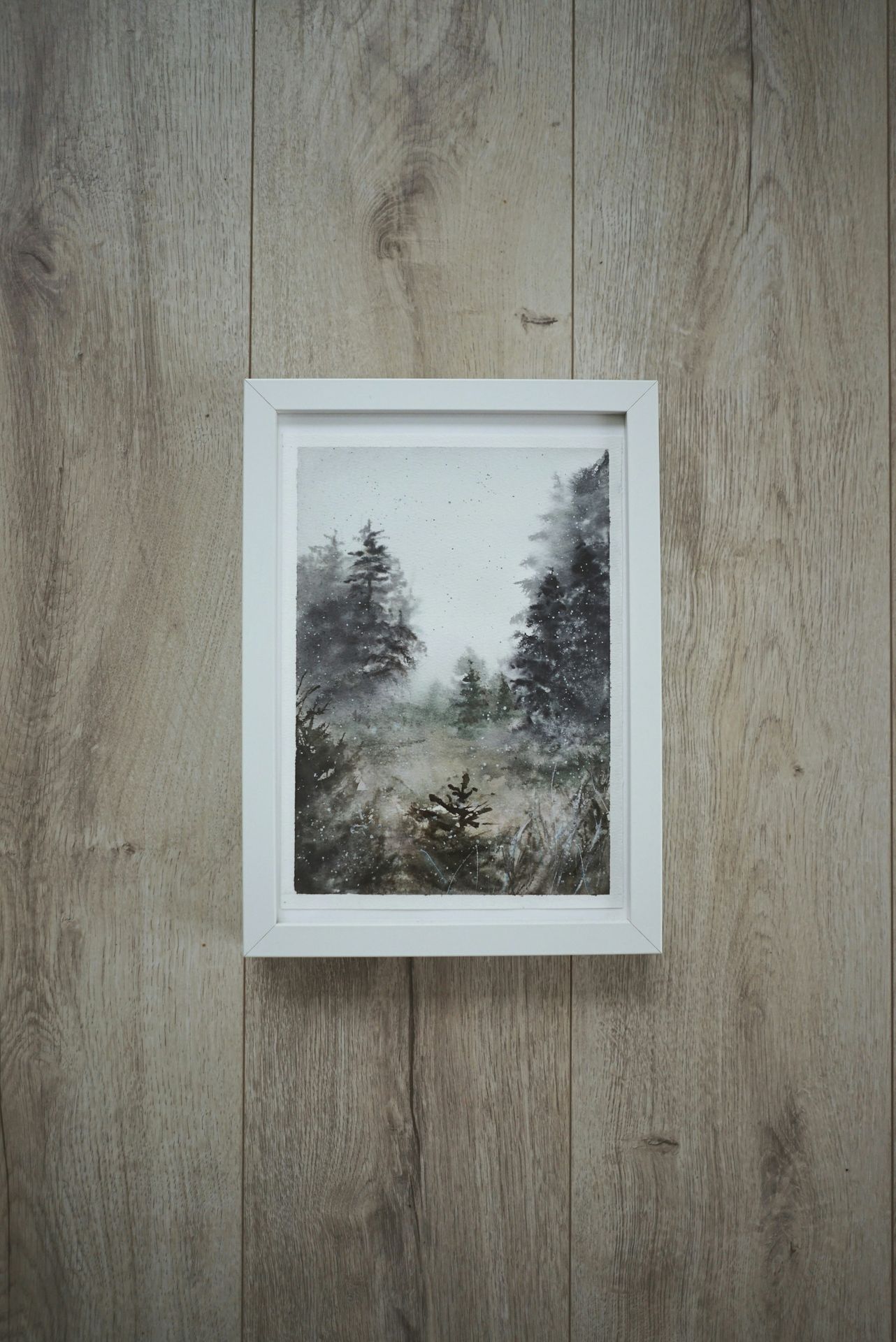 a picture hanging on a wall of a forest
